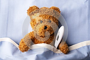 Sick teddy bear on hospital bed