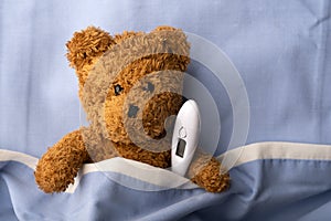 Sick teddy bear on hospital bed