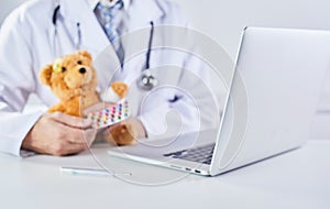 Sick teddy bear receiving medication from doctor