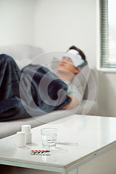 sick wasted man lying in sofa suffering cold and winter flu virus