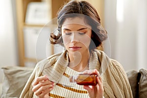Sick woman with antipyretic or cough syrup at home