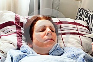 Sick woman in bed. Headache, runny nose and cold. Paleness of the face and faintness of the body. Feeling unwell. The photo