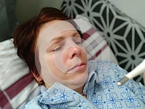 Sick woman in bed. Headache, runny nose and cold. Paleness of the face and faintness of the body. Feeling unwell. The photo