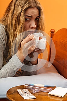 Sick woman in bed sneezing in tissue. Cold.