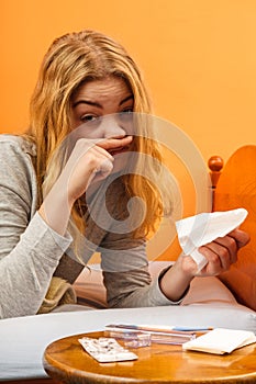 Sick woman in bed sneezing in tissue. Cold.