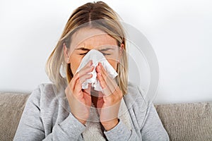 Sick woman blowing her nose