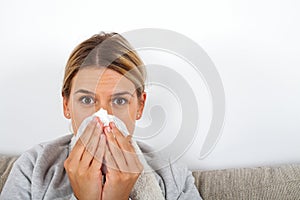 Sick woman blowing her nose