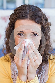 Sick woman blowing her nose