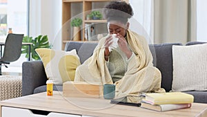 Sick woman blowing her runny nose with a tissue at home. Miserable female feeling unwell with flu, cold and covid