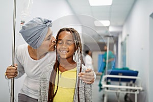 Sick woman with cancer hugging her young grandchild in hospital. Family support concept.