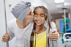 Sick woman with cancer hugging her young grandchild in hospital. Family support concept.