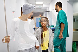 Sick woman with cancer hugging her young grandchild in hospital. Family support concept.