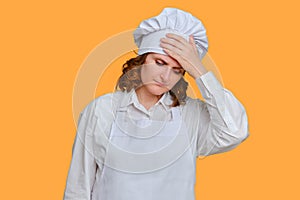 Sick woman chef is sad with her hands to her sore head on studio background, mockup copy space