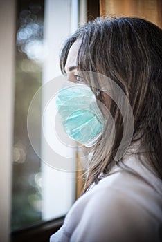 Sick woman of corona virus looking through the window