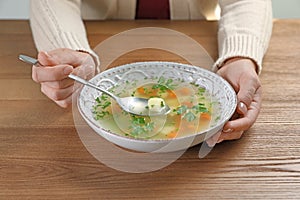 Sick woman eating fresh homemade soup to cure flu