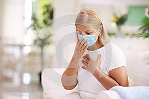 Sick woman in face mask. Ill senior coughing