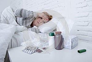 sick woman feeling bad ill lying on bed suffering headache winter cold and flu virus having medicines