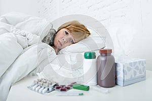 sick woman feeling bad ill lying on bed suffering headache winter cold and flu virus having medicines