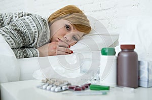 Sick woman feeling bad ill lying on bed suffering headache winter cold and flu virus having medicines