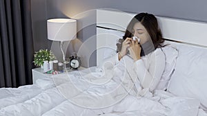 Sick woman feeling cold and sneezing in bed