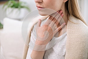 sick woman feeling throat sore and touching her neck