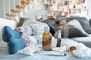 Sick woman with flu, cold, fever or virus sitting on sofa at home