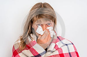 Sick woman with flu or cold sneezing into handkerchief