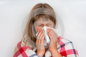 Sick woman with flu or cold sneezing into handkerchief