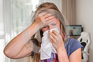 Sick woman with flu or cold sneezing into handkerchief