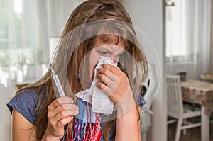 Sick woman with flu or cold sneezing into handkerchief