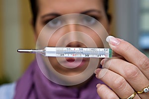 The sick woman with flu and fever thermometers photo