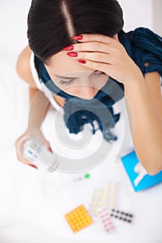 Sick Woman. Flu. Girl with cold lying under a blanket holding a