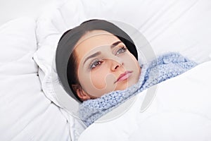 Sick Woman. Flu. Girl with cold lying under a blanket holding a