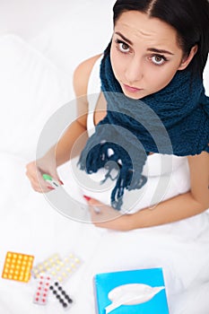 Sick Woman. Flu. Girl with cold lying under a blanket holding a