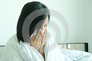 Sick woman is flu, using a paper napkin and he have a runny nose. And he was covered in warm cloth.Health concept