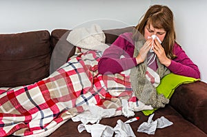 Sick woman having flu and blowing her runny nose