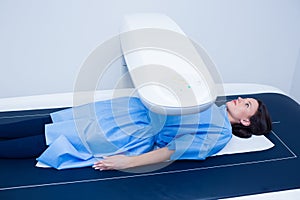 Sick woman lying on a x-ray machine