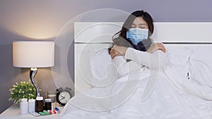 Sick woman in medical mask feeling cold and suffering from virus disease and fever in bed, coronavirus covid-19 pandemic concept