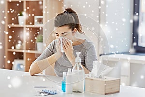 Sick woman with medicine blowing nose to wipe