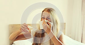 Sick woman sneezing blow nose using tissue measuring checking body temperature with thermometer