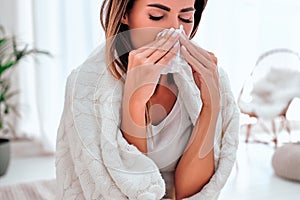 Sick woman sneezing into tissue. Allergy reaction. Flu. Woman caught cold