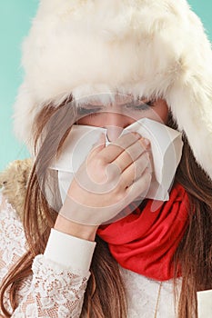 Sick woman sneezing in tissue. Winter cold.