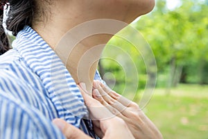Sick woman suffering from sore throat,painful swallowing,tonsillitis,irritation,asian female patient checking thyroid gland by