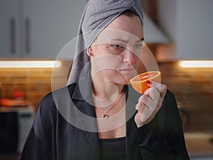 Sick woman trying to sense smell of fresh orange