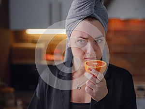 Sick woman trying to sense smell of fresh orange