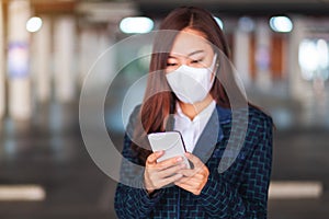 A sick woman wearing protective face mask, using mobile phone for Healthcare and Covid-19 concept