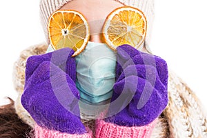 Sick woman wearing surgical mask and orange slices