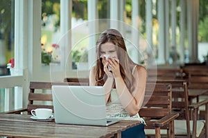 Sick woman working on laptop