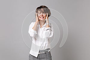 Sick young business woman in white shirt posing isolated on grey background. Achievement career wealth business concept