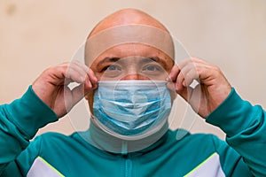 Sick young man with medical face mask portrait close up illustrates pandemic coronavirus disease on blurred background. Covid-19